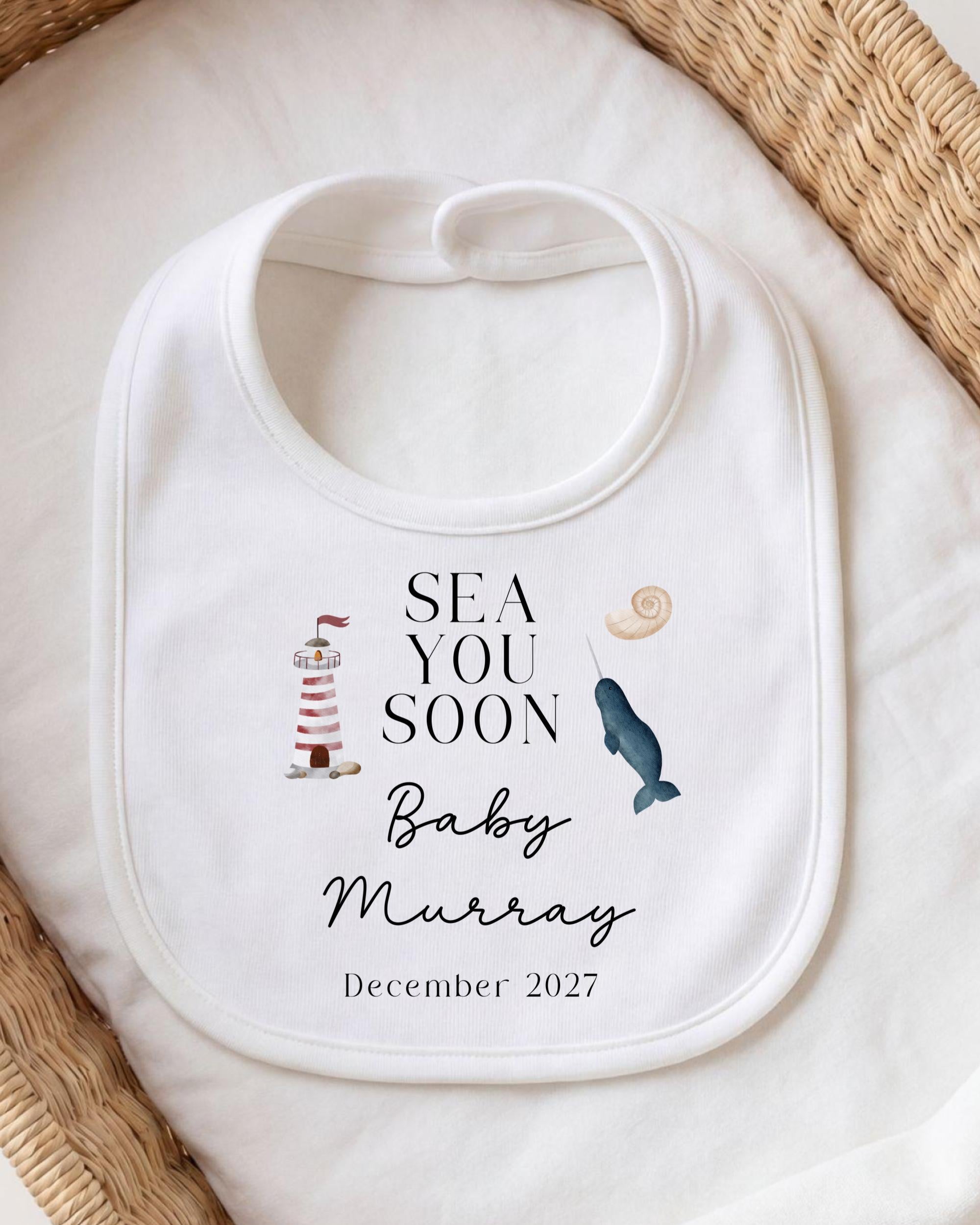 a white bib with a personalized message and illustrations related to a baby announcement.