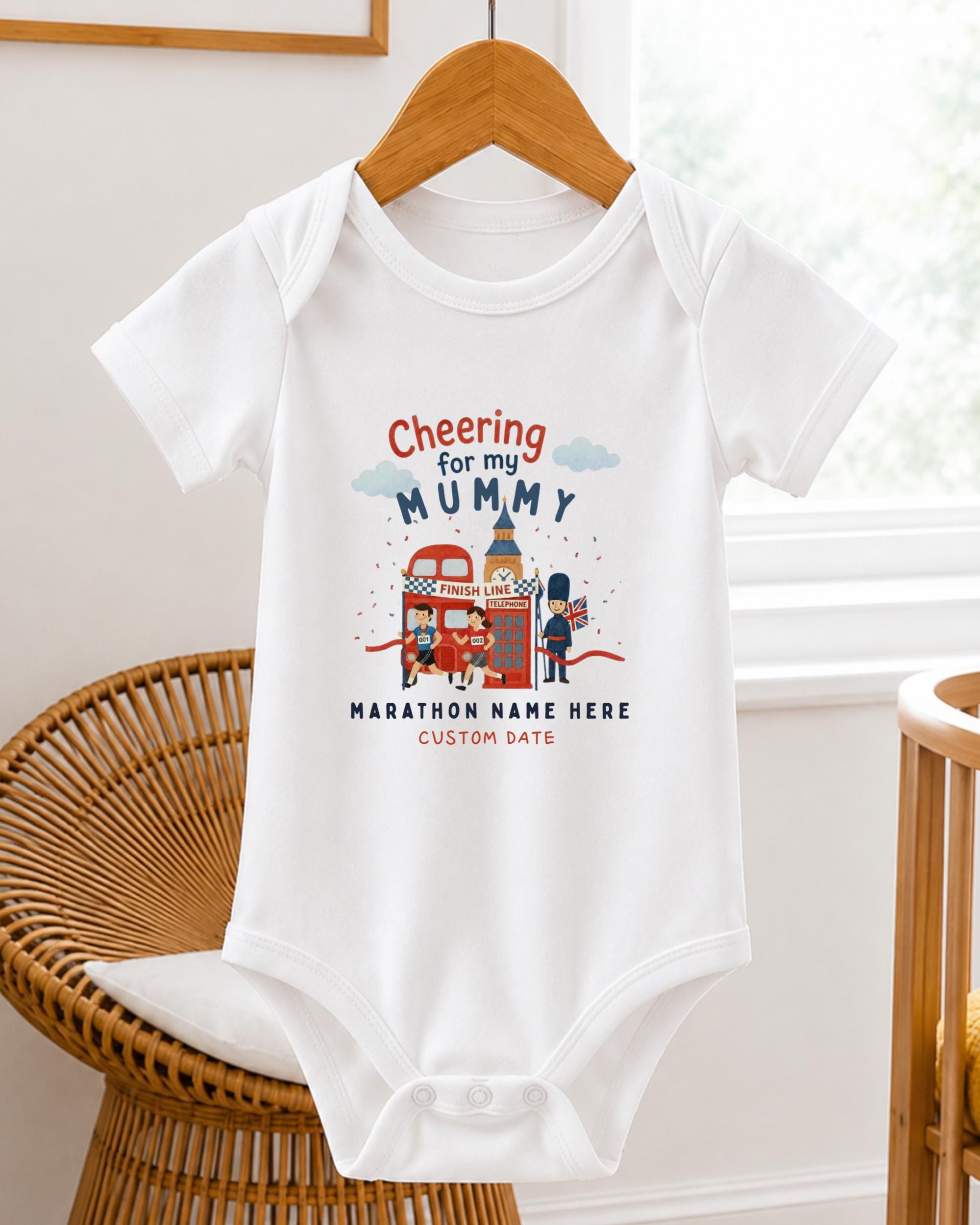 A white baby onesie with a graphic design on it, hanging on a wooden hanger.