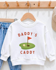 A white sweatshirt with a graphic design on it, hanging on a wooden hanger.