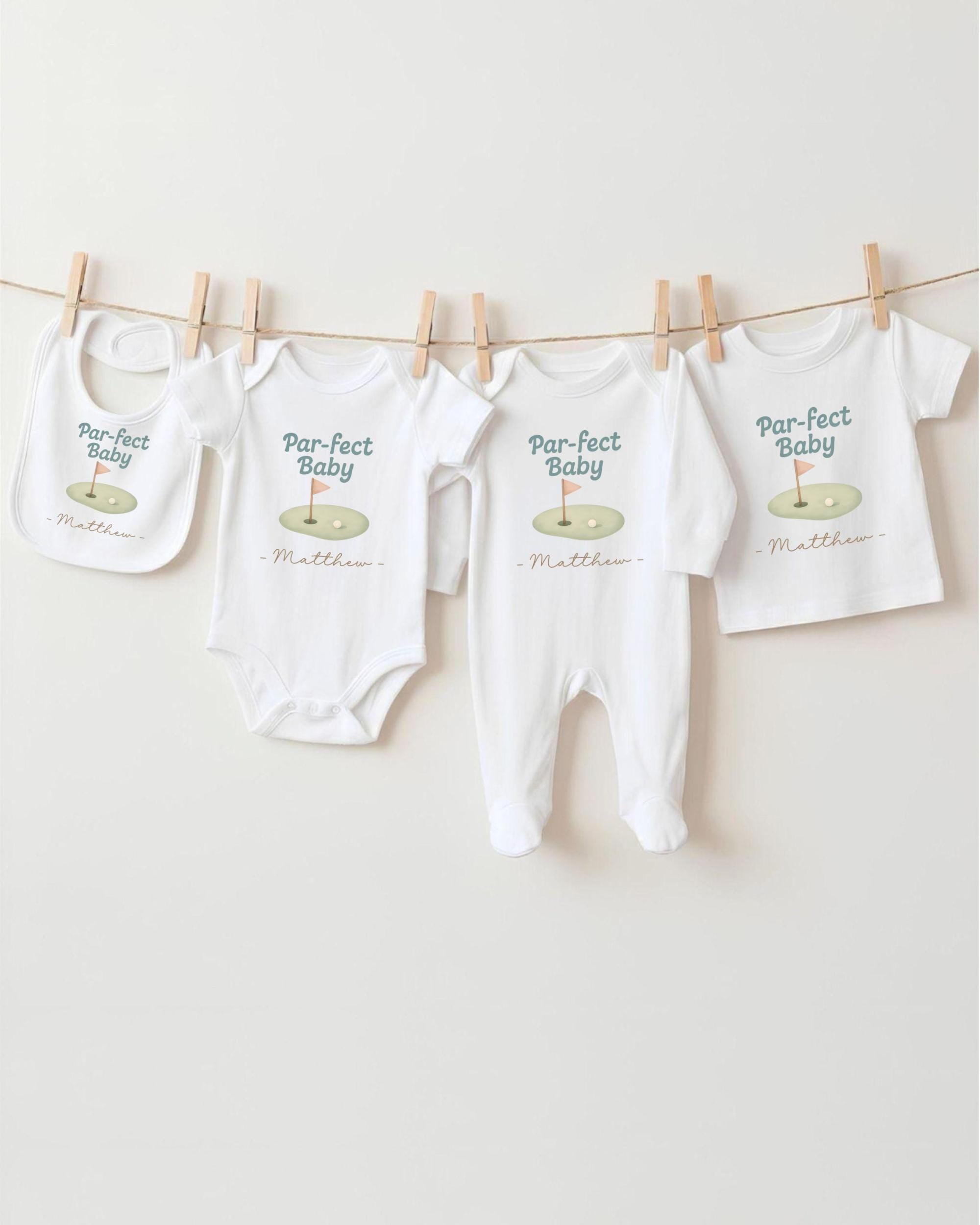 a collection of baby clothes, including onesies and bibs, hanging on a clothesline.
