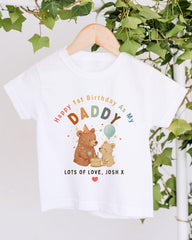 A white t-shirt with a colorful graphic design featuring two bears and a balloon, along with text that reads "Happy 1st Birthday As My Daddy Lots of Love, Josh X".
