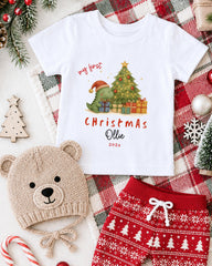 A white t-shirt with a Christmas-themed graphic, a beige knit hat, red shorts, and various Christmas decorations such as a Christmas tree, ornaments, and a snowflake.
