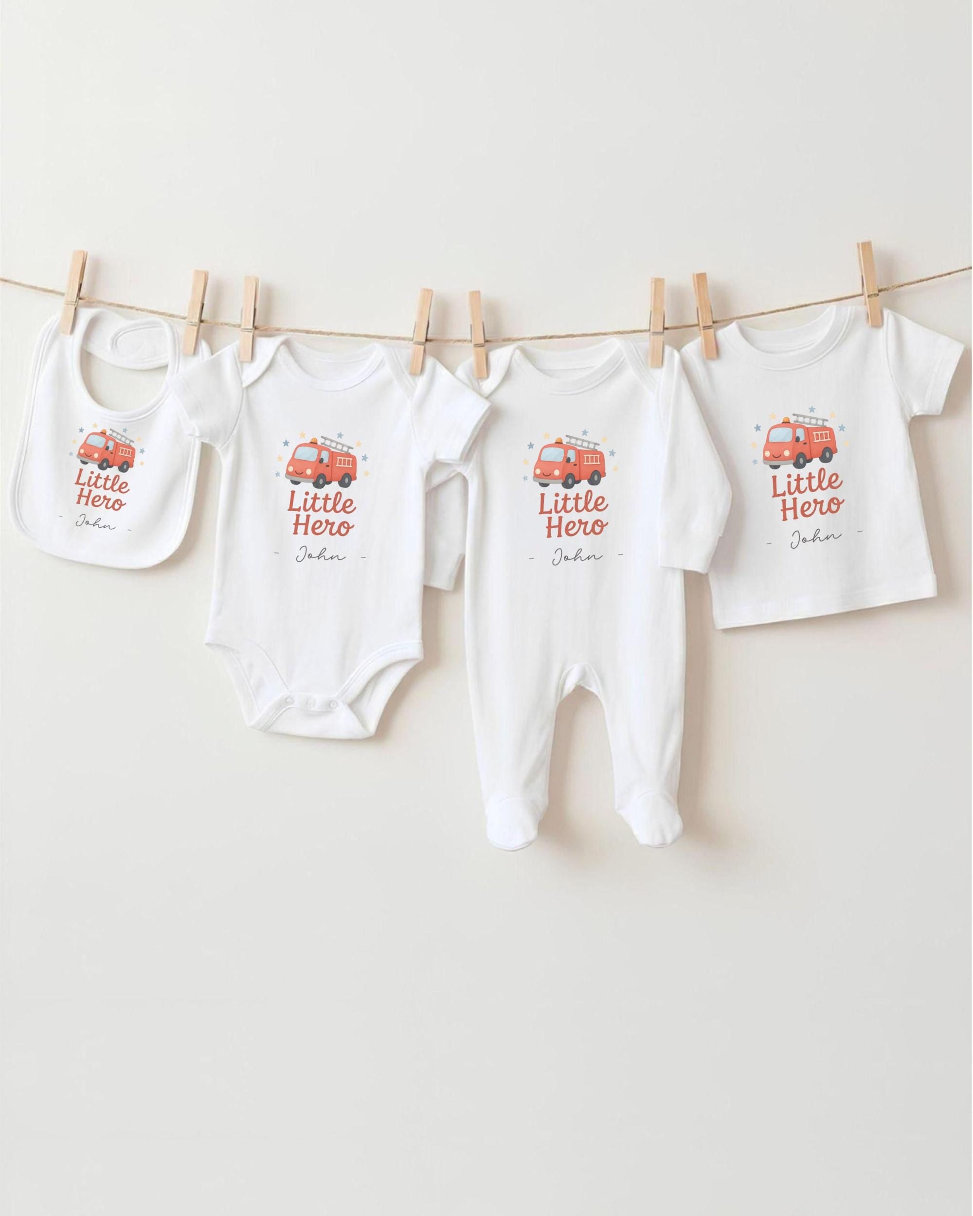 A collection of baby clothes, including onesies and bibs, hanging on a clothesline.