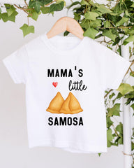 A white t-shirt with a graphic design featuring a heart symbol and the text "MAMA'S little SAMOSA" printed on it.