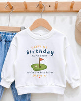 A white sweatshirt with a personalized message printed on it, hanging on a wooden hanger.