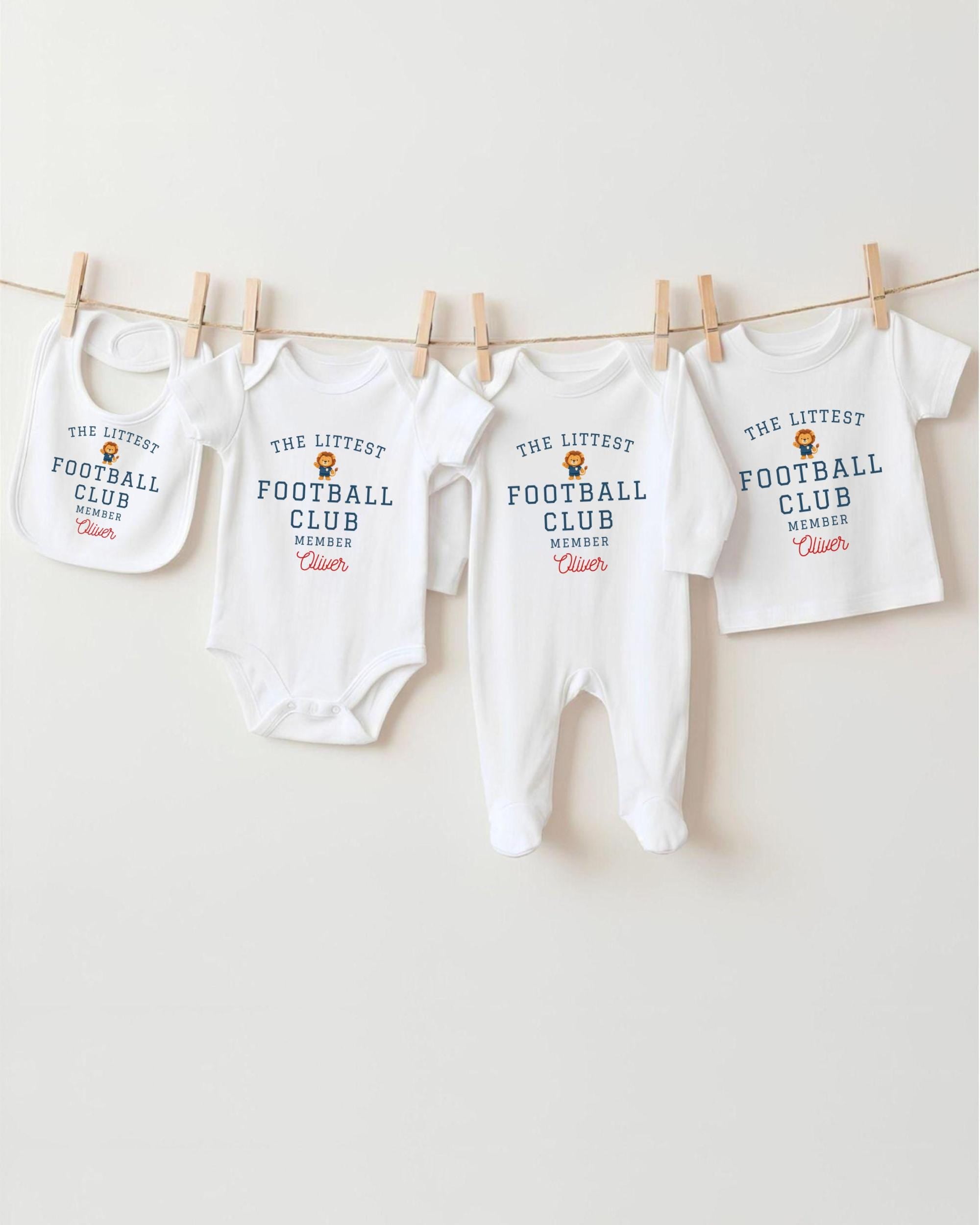 A row of four white baby clothes, including onesies and bibs, hanging on a clothesline.
