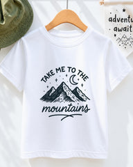 A white t-shirt with a graphic design of mountains and a crescent moon, along with the text "Take me to the mountains" printed on it.