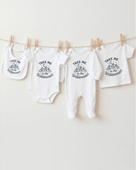 A collection of baby clothes, including onesies and bibs, hanging on a clothesline.