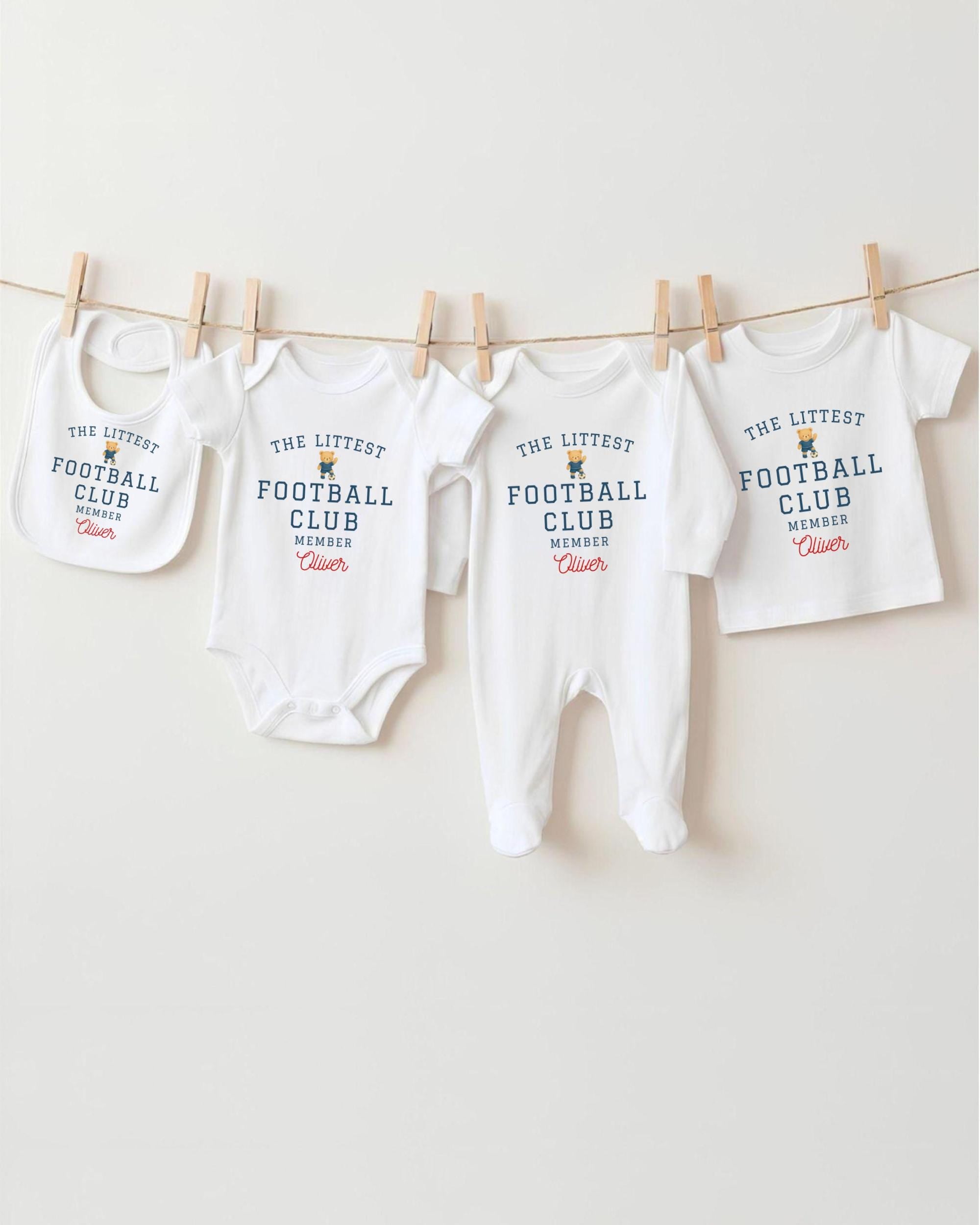 A row of four white baby clothes, including onesies and bibs, hanging on a clothesline.