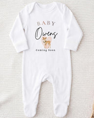A white onesie with text and an illustration of a deer on it.