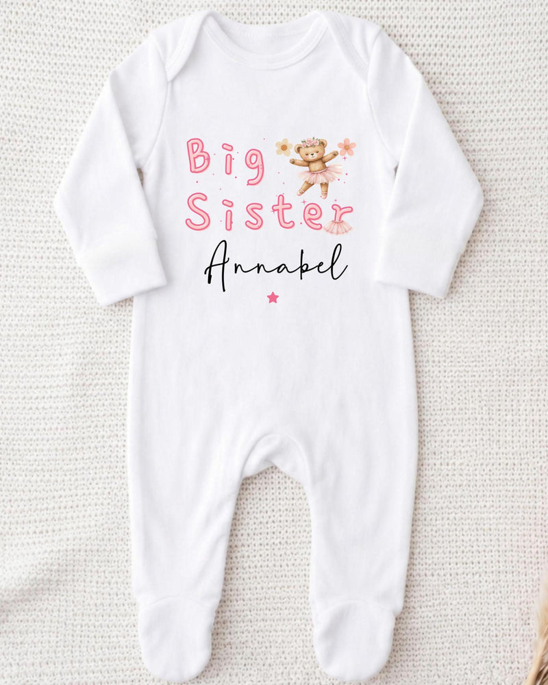 A white bodysuit with the text "Big Sister Annabel" printed on it, along with a small illustration of a teddy bear.