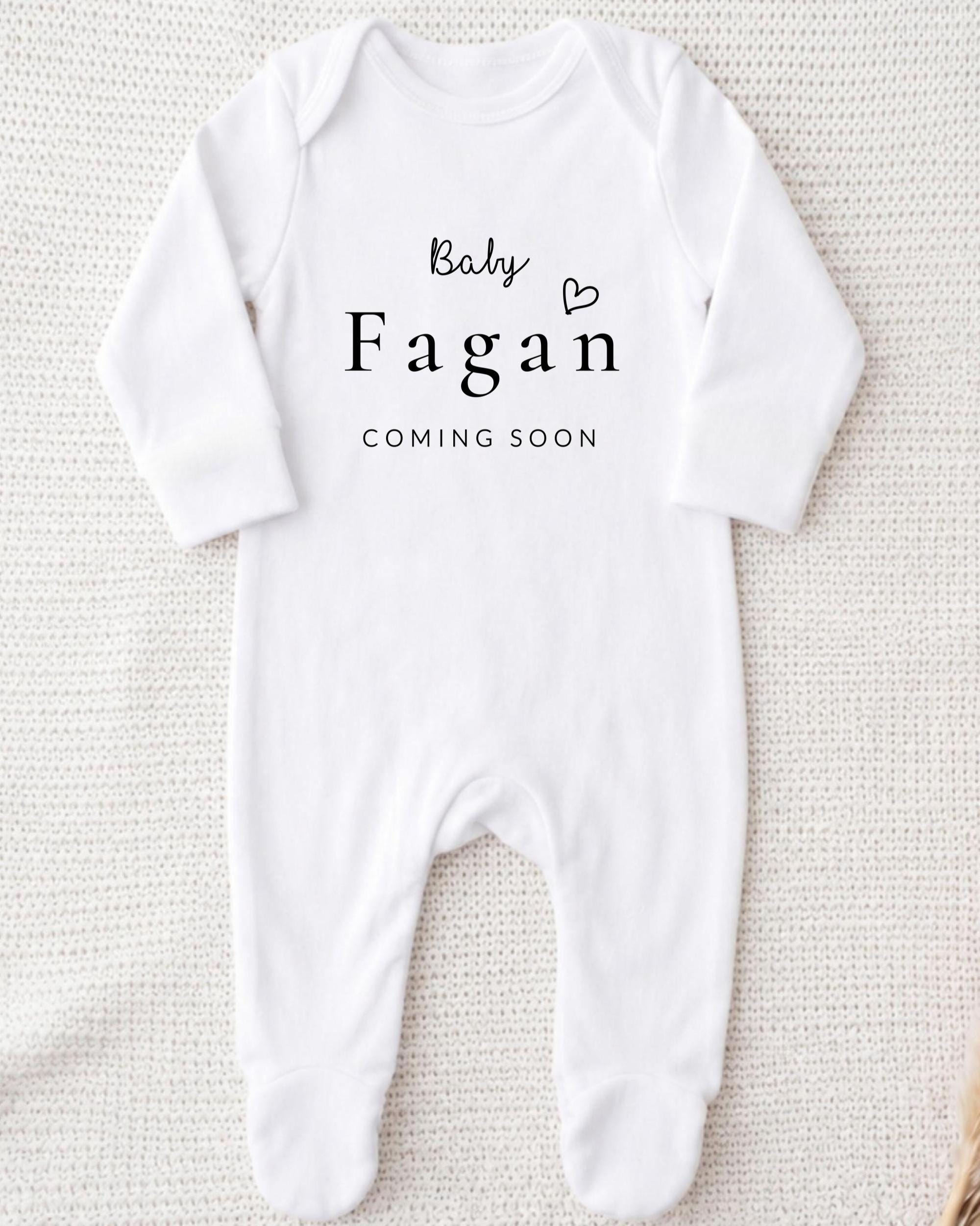 A white onesie with the text "Baby Fagan" and "Coming soon" printed on it.