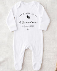 A white onesie with the text "Get ready to be a Grandma In January 2028" printed on it.