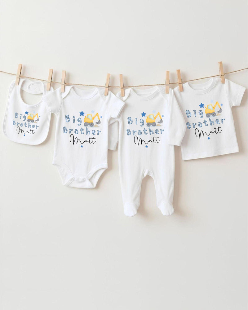 A row of four white baby clothes with the text "Big Brother Matt" printed on them, hanging on a clothesline.