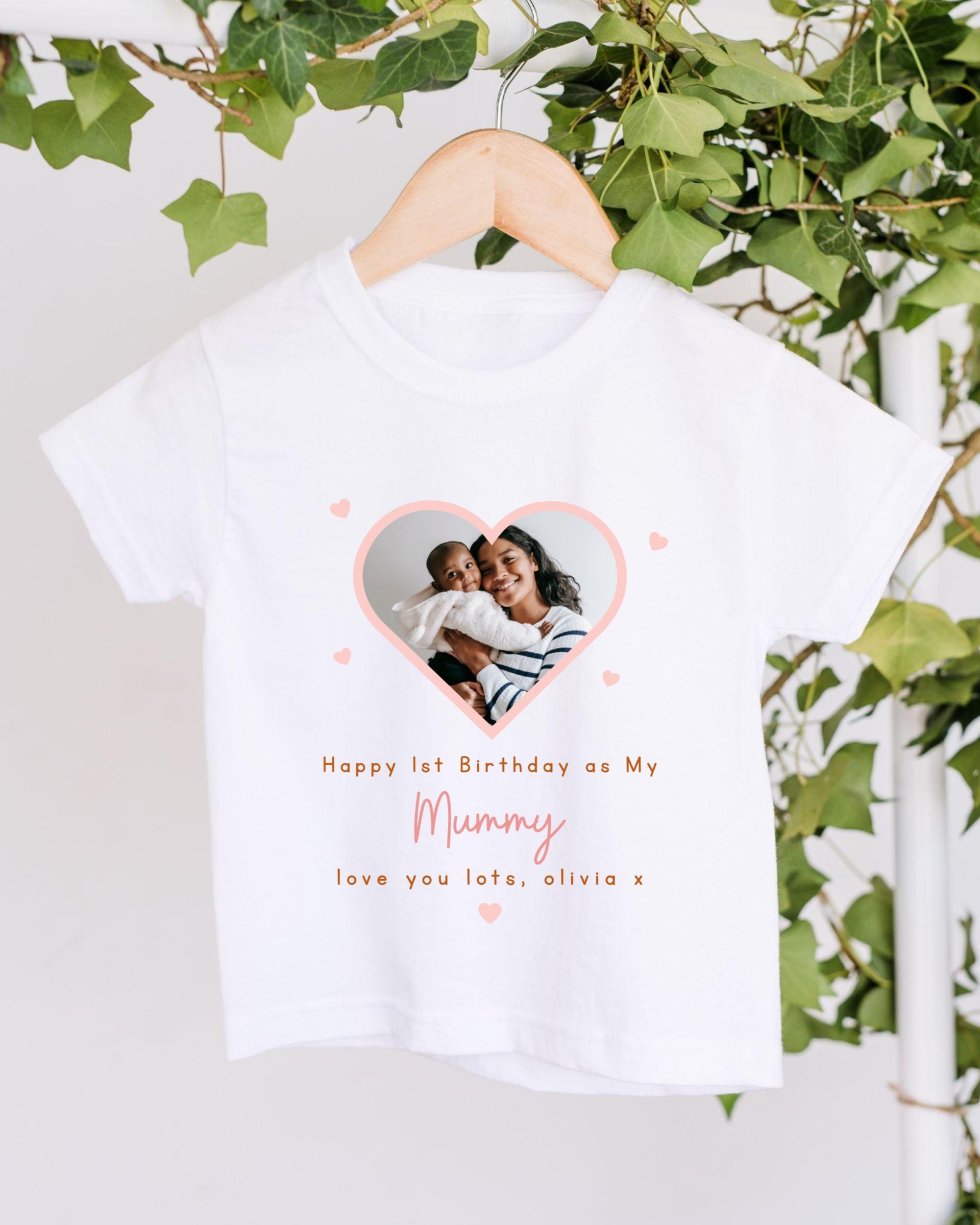 A white t-shirt with a heart-shaped photo of a woman and a child, along with the text "Happy 1st Birthday as My Mummy, love you lots, Olivia x" printed on it.