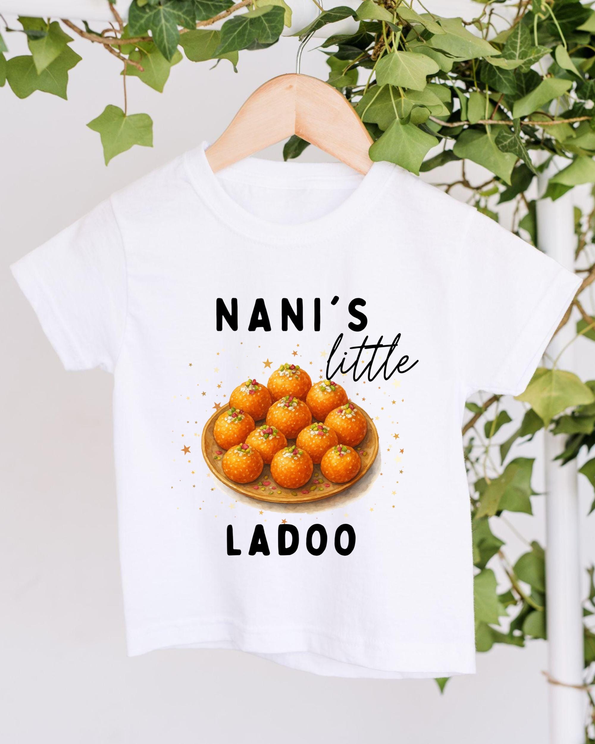 A white t-shirt with a graphic design featuring a plate of oranges and the text "NANI'S little LADOO" printed on it.