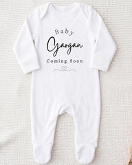 A white onesie with the text "Baby Gargan Coming Soon" printed on it.