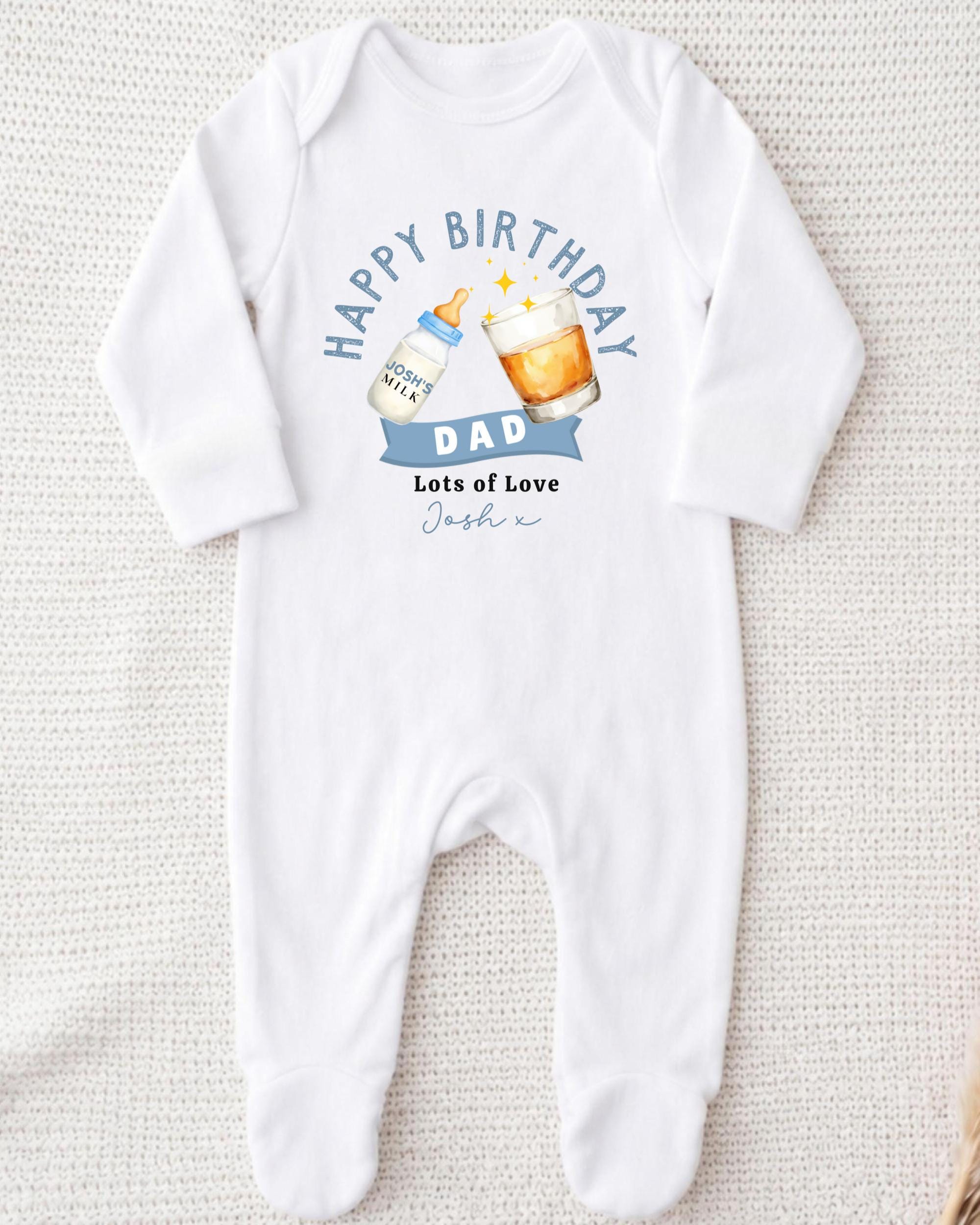 A white onesie with a birthday message and illustrations of a bottle of milk and a glass of beer.