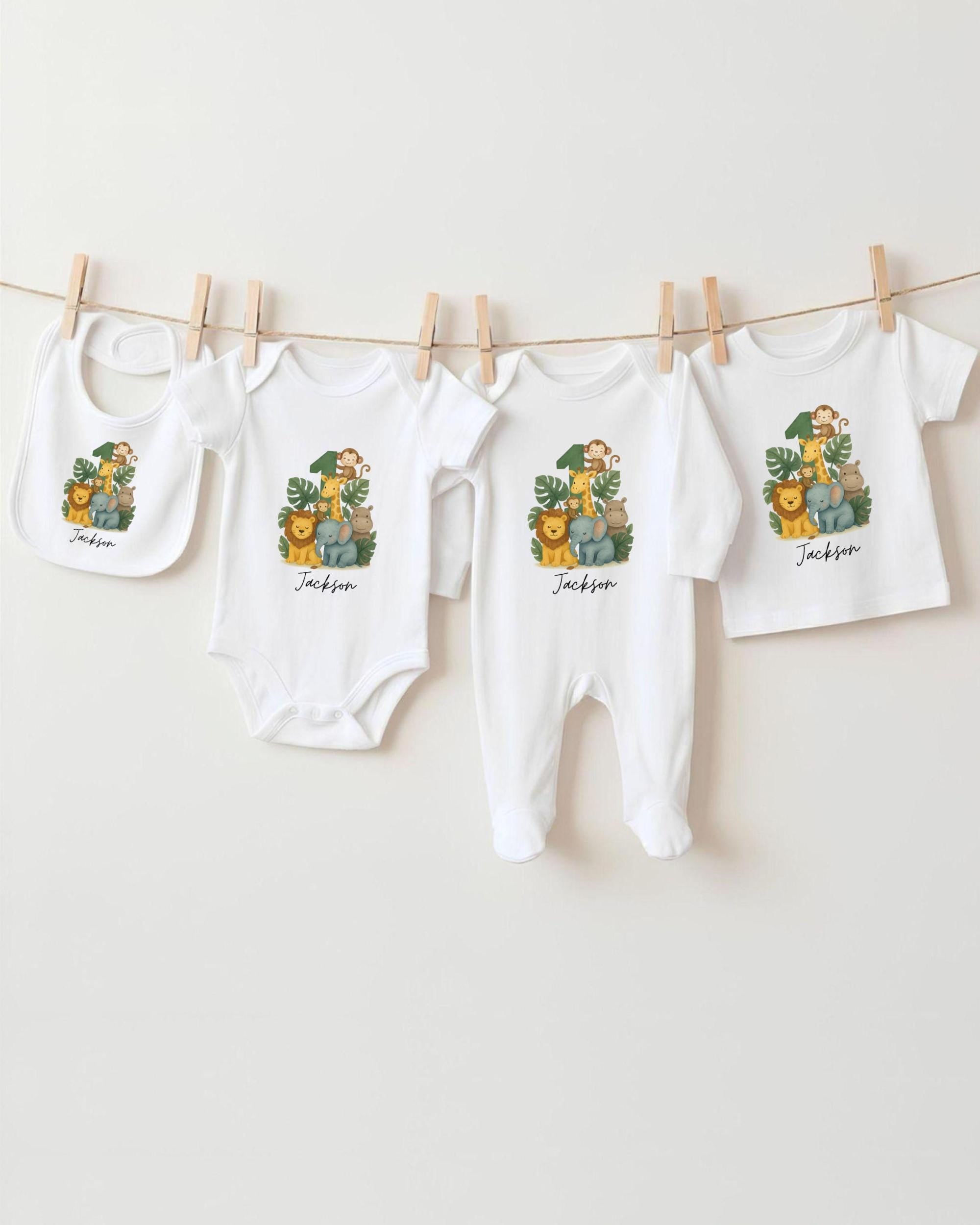 A collection of baby clothes, including onesies and bibs, hanging on a clothesline.