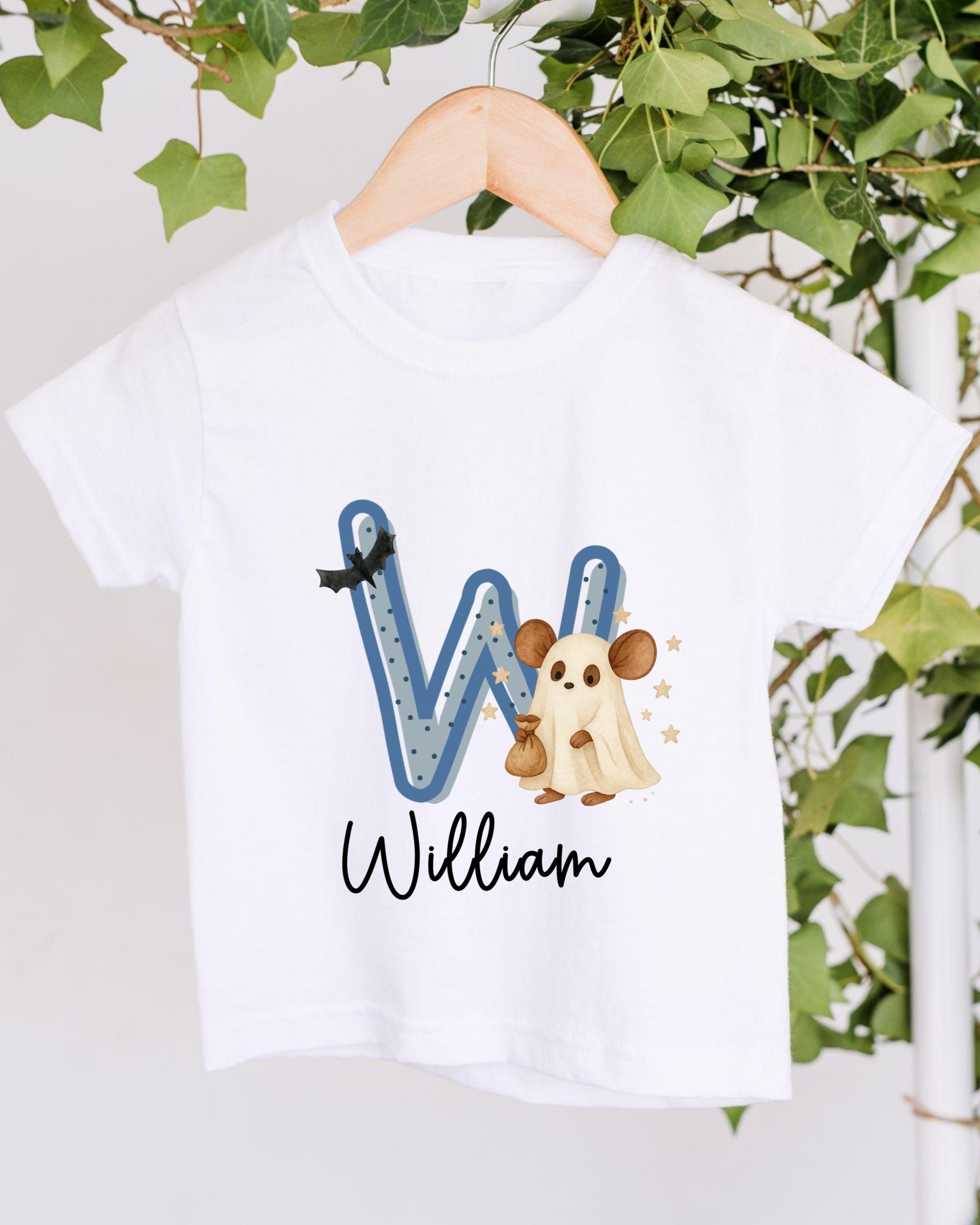 A white t-shirt with a graphic design featuring a letter "W" and a cartoon character, along with the name "William" written below.