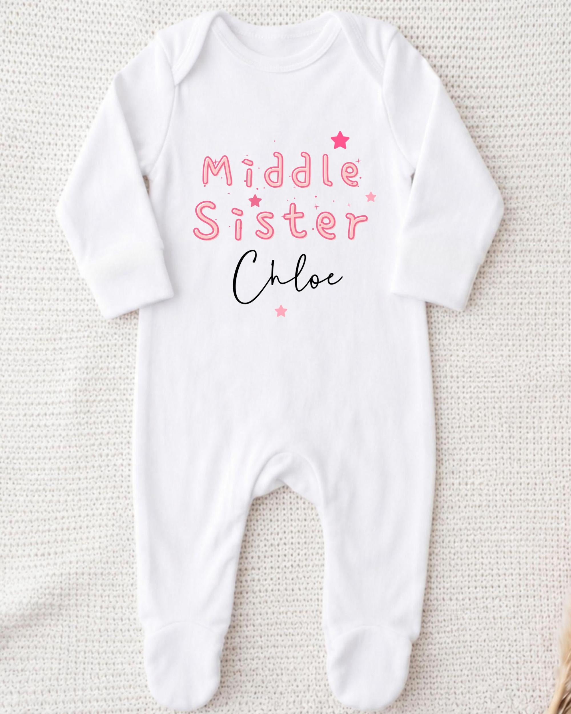 A white onesie with the text "Middle Sister Chloe" printed on it.