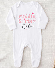 A white onesie with the text "Middle Sister Chloe" printed on it.