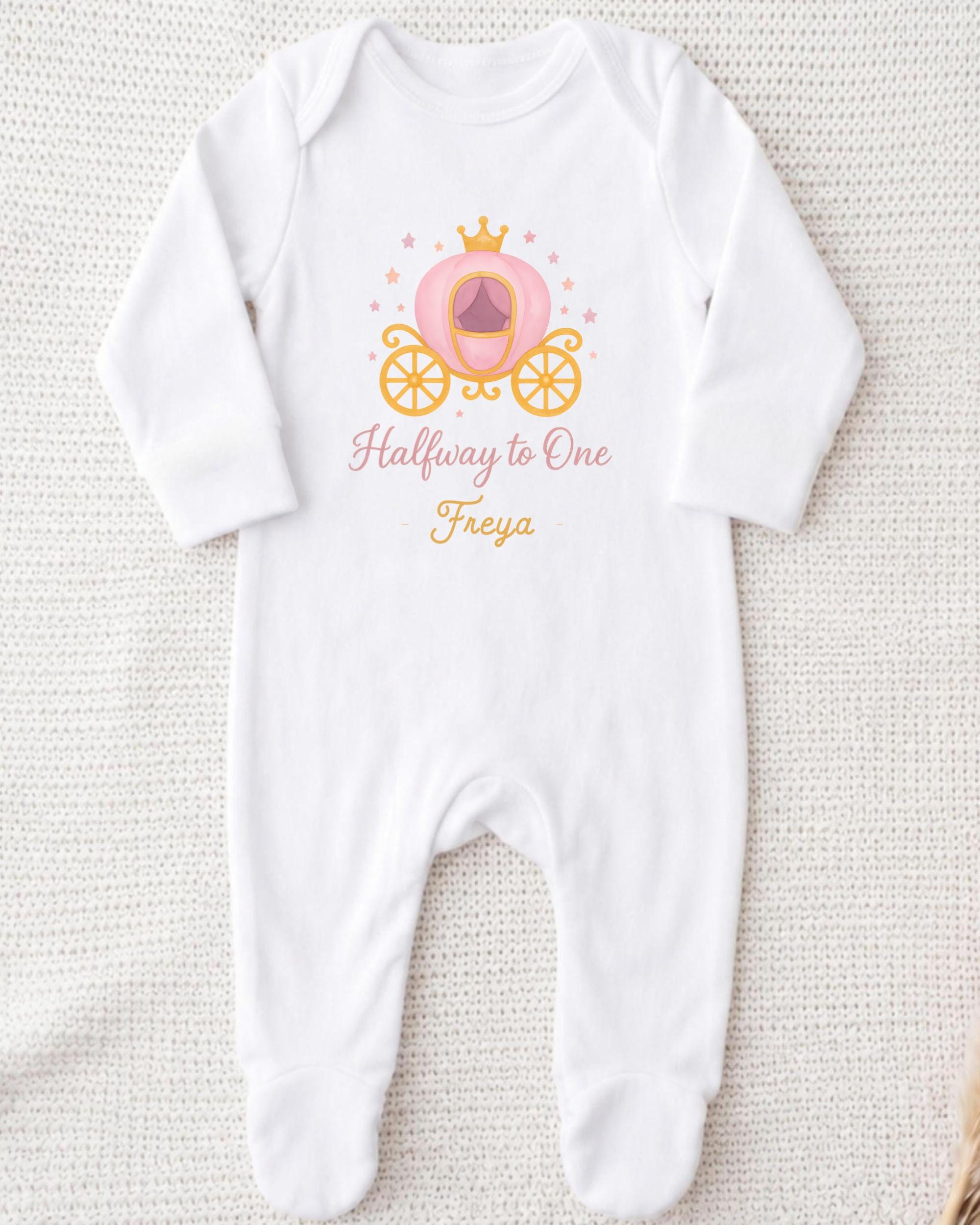 A white onesie with a pink carriage and the text "Halfway to One Freya" printed on it.