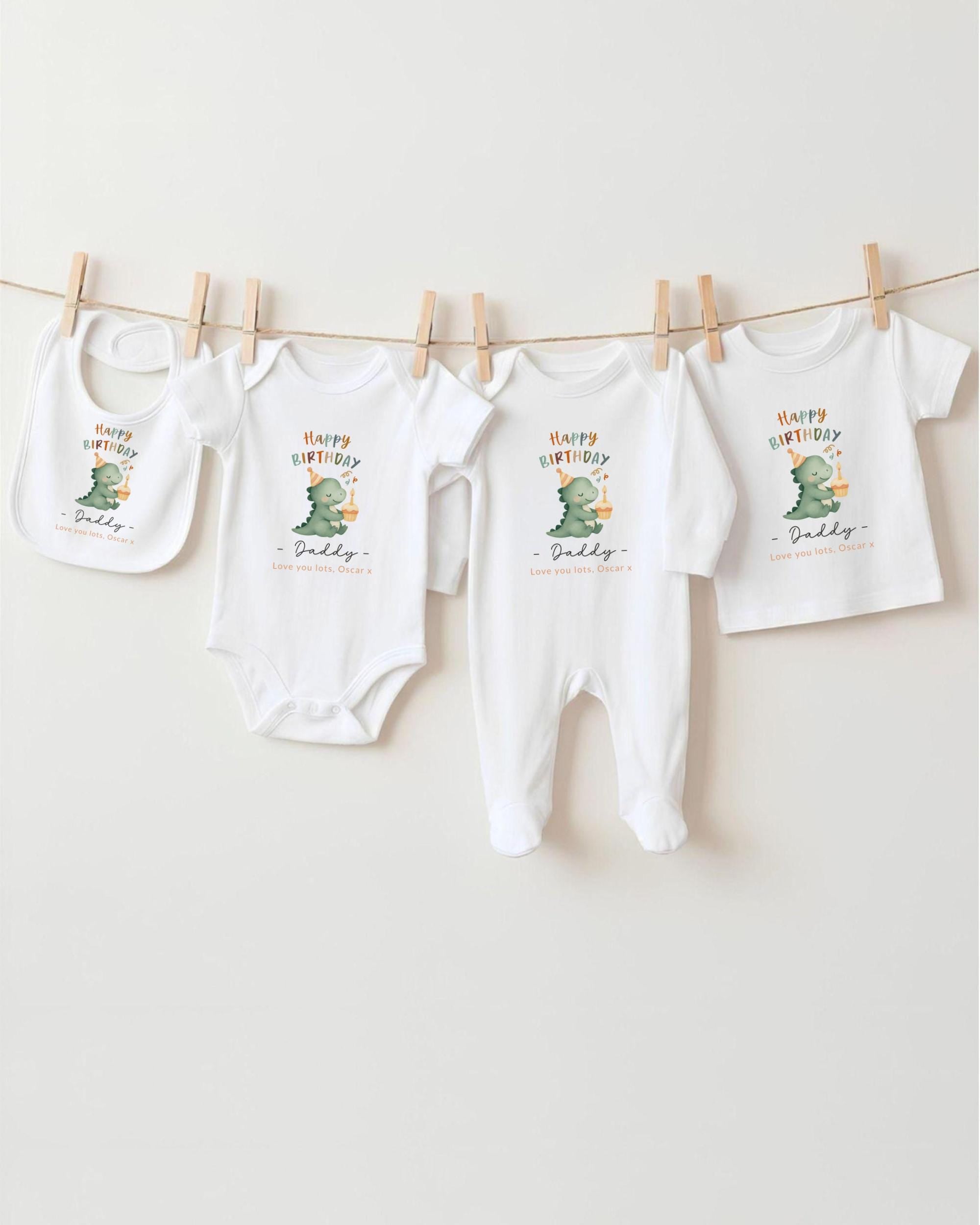 A collection of white baby clothes, including onesies and bibs, hanging on a clothesline.