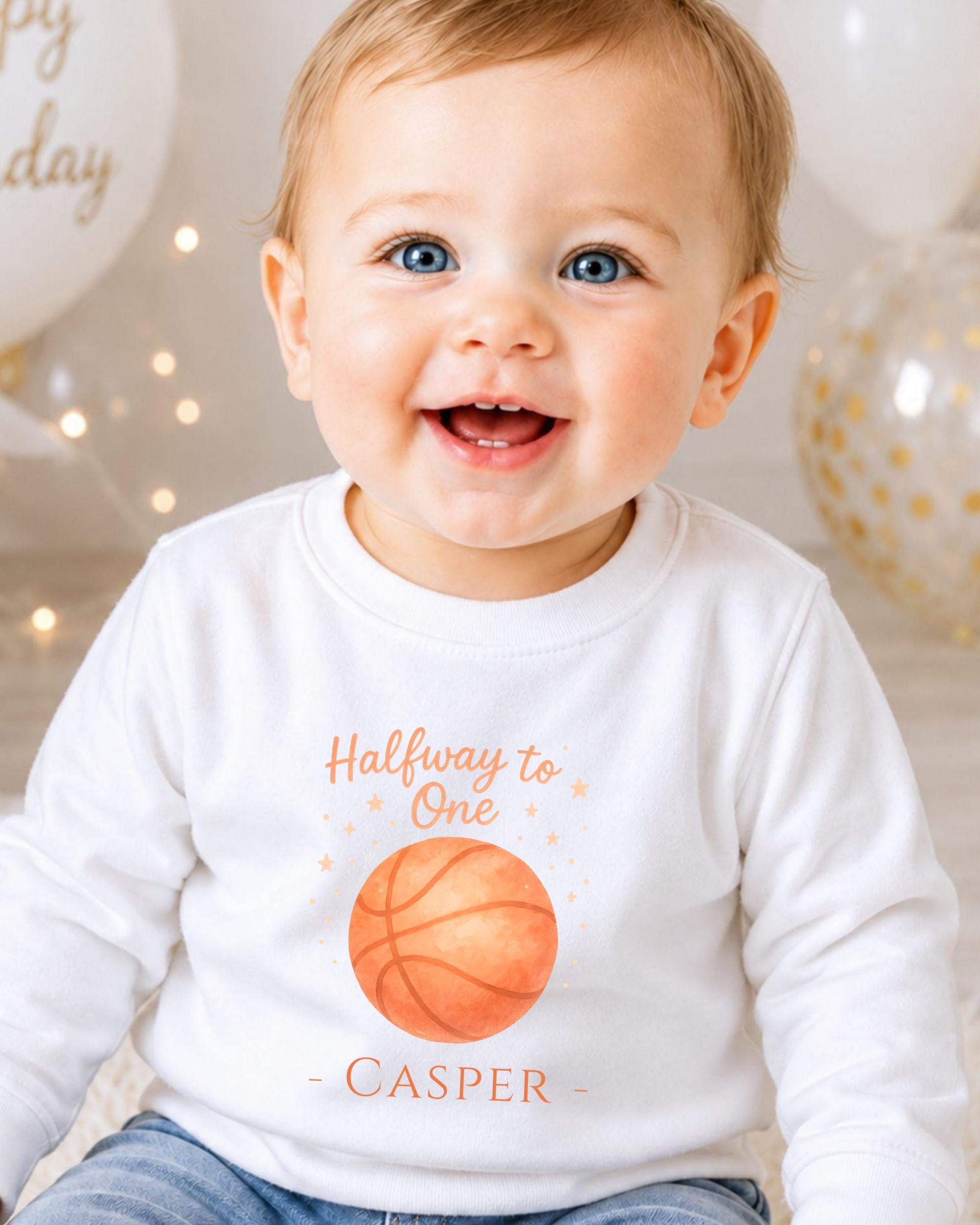 A smiling baby boy wearing a white t-shirt with a basketball graphic and text that says "Halfway to One - CASPER".