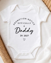 A white baby onesie with text printed on it.