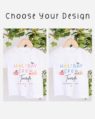 two white t-shirts hanging on a wooden hanger, each with a different design and text. The text on the t-shirts reads "HOLIDAY CREW" and "Tenerife", suggesting they are related to a holiday crew or vacation destination.