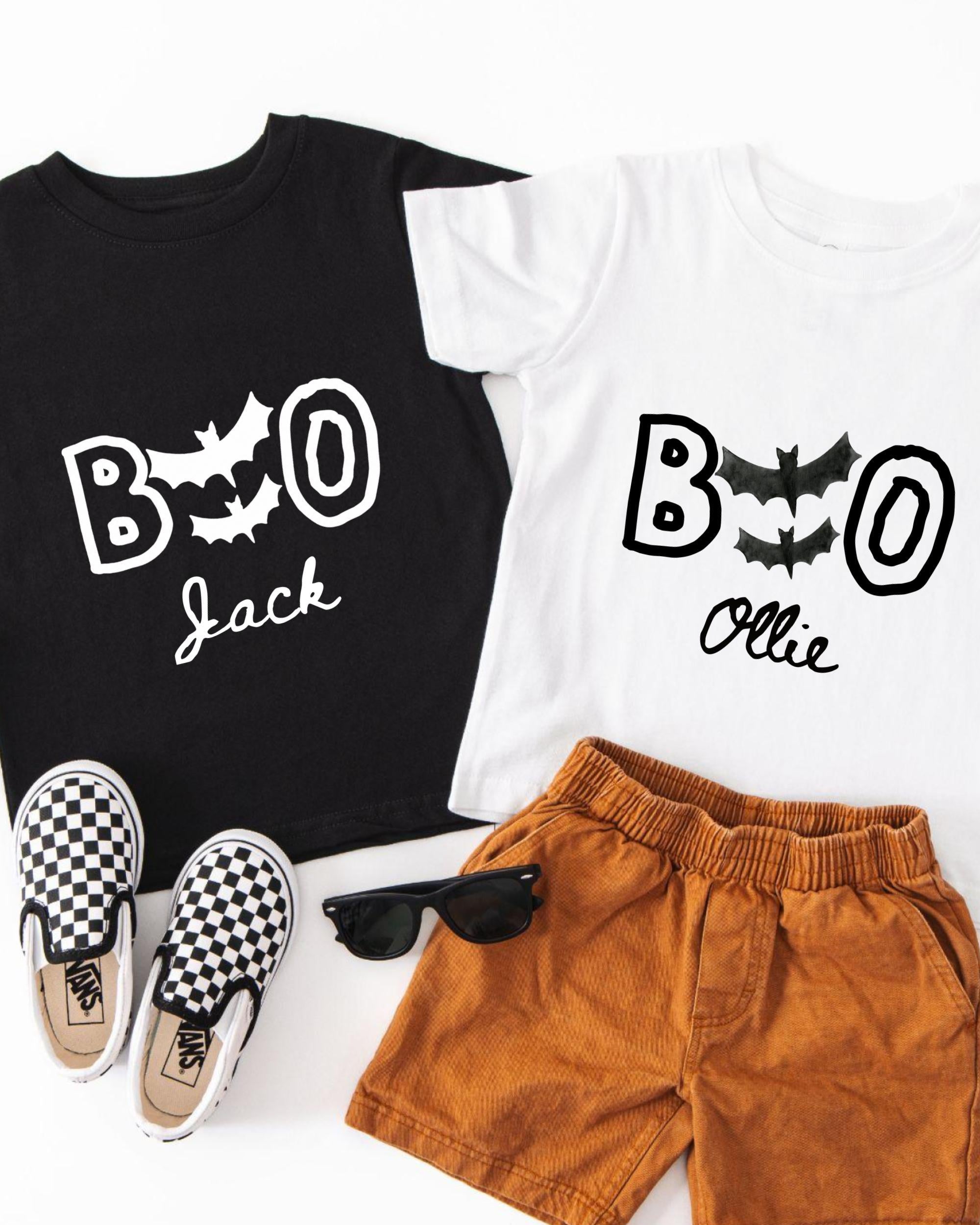 A black t-shirt with the text "BOO Jack" and a white t-shirt with the text "BOOollie" printed on them, along with a pair of brown shorts and a pair of black and white checkered shoes.