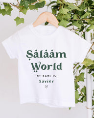 A white t-shirt with the text "Sälääm World" printed on it, hanging on a wooden hanger.