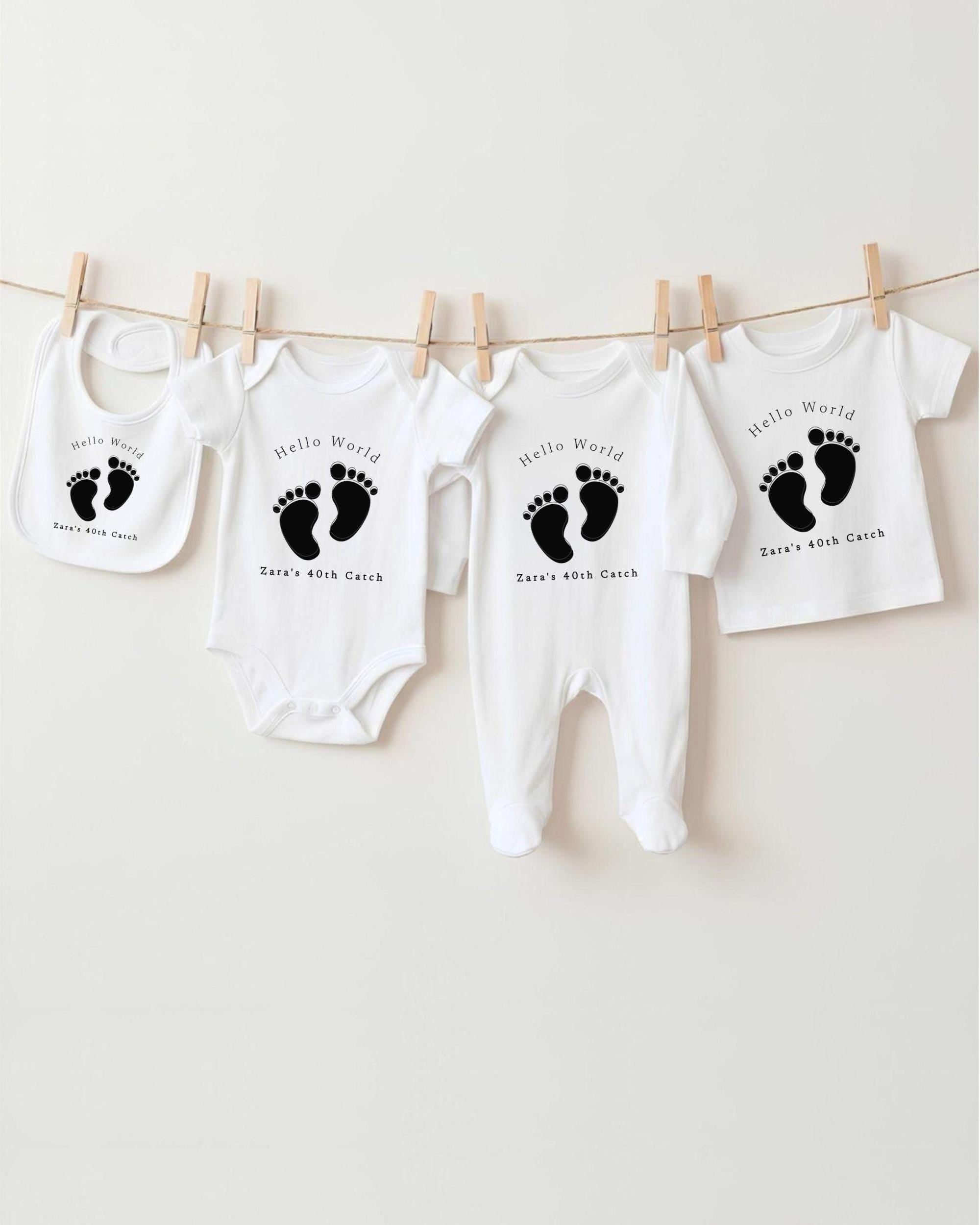 A collection of baby clothes, including onesies and bibs, hanging on a clothesline.
