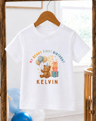 A white t-shirt with a printed design of a teddy bear and balloons, along with the text "My Beary First Birthday" and the name "Kevin".