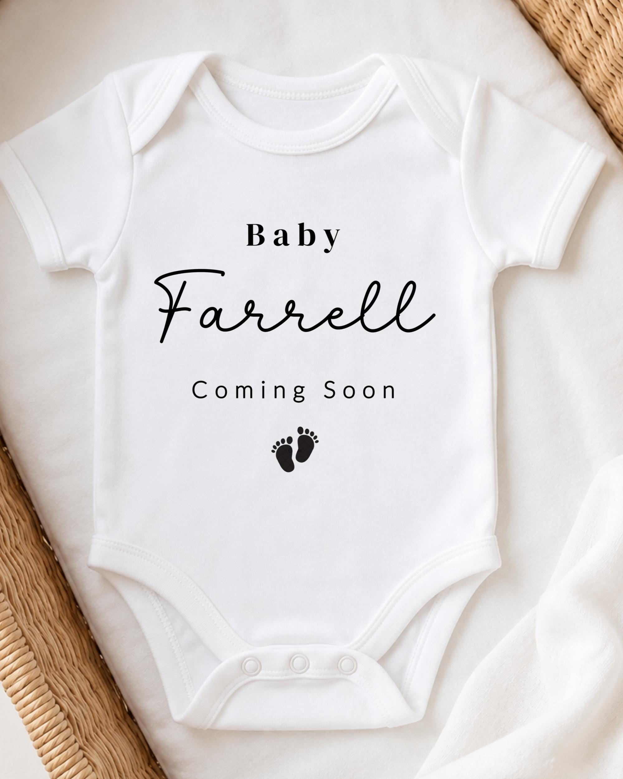 A white baby onesie with the text "Baby Farrell Coming Soon" printed on it.