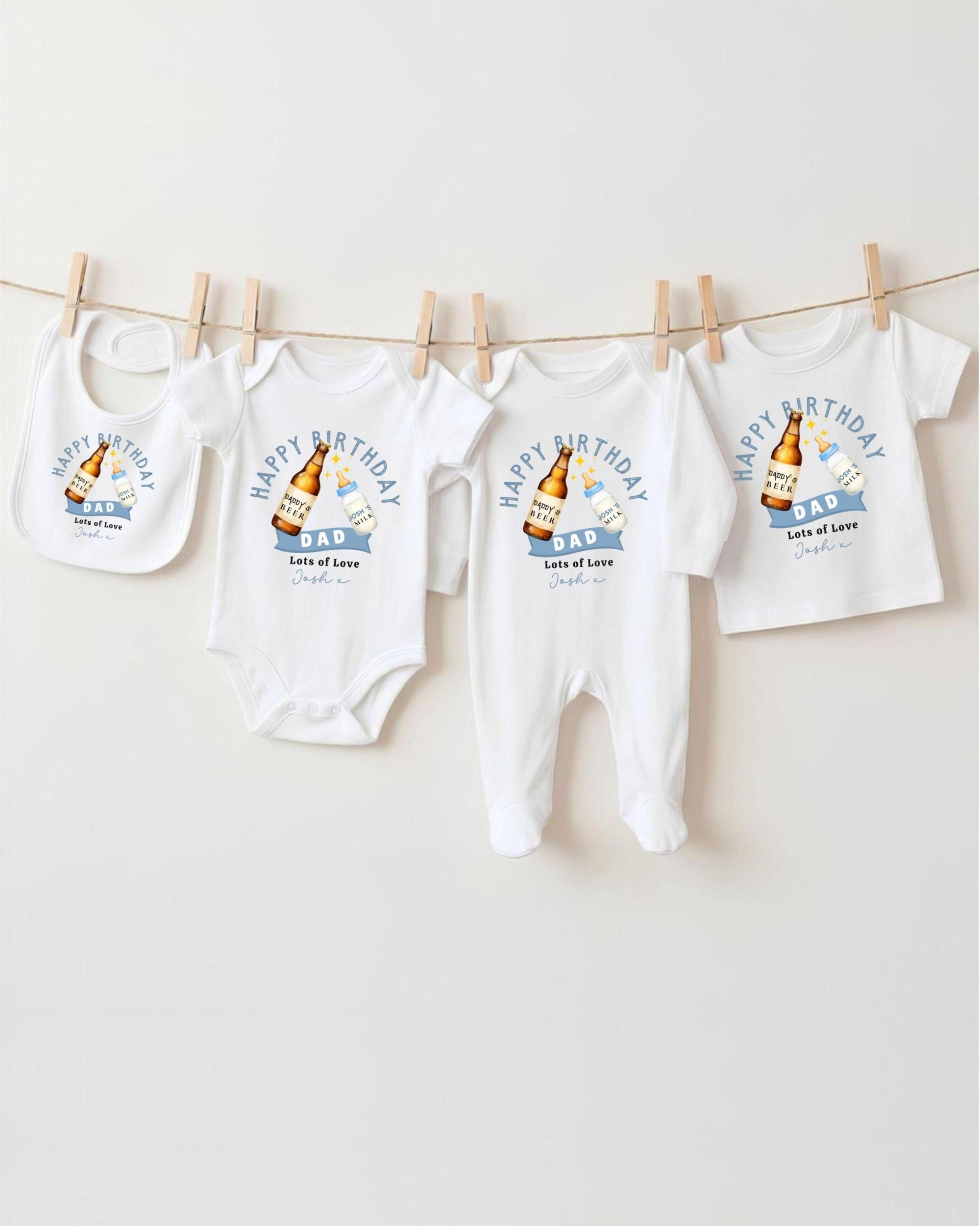 A collection of four white baby clothes, including onesies and bibs, hanging on a clothesline.
