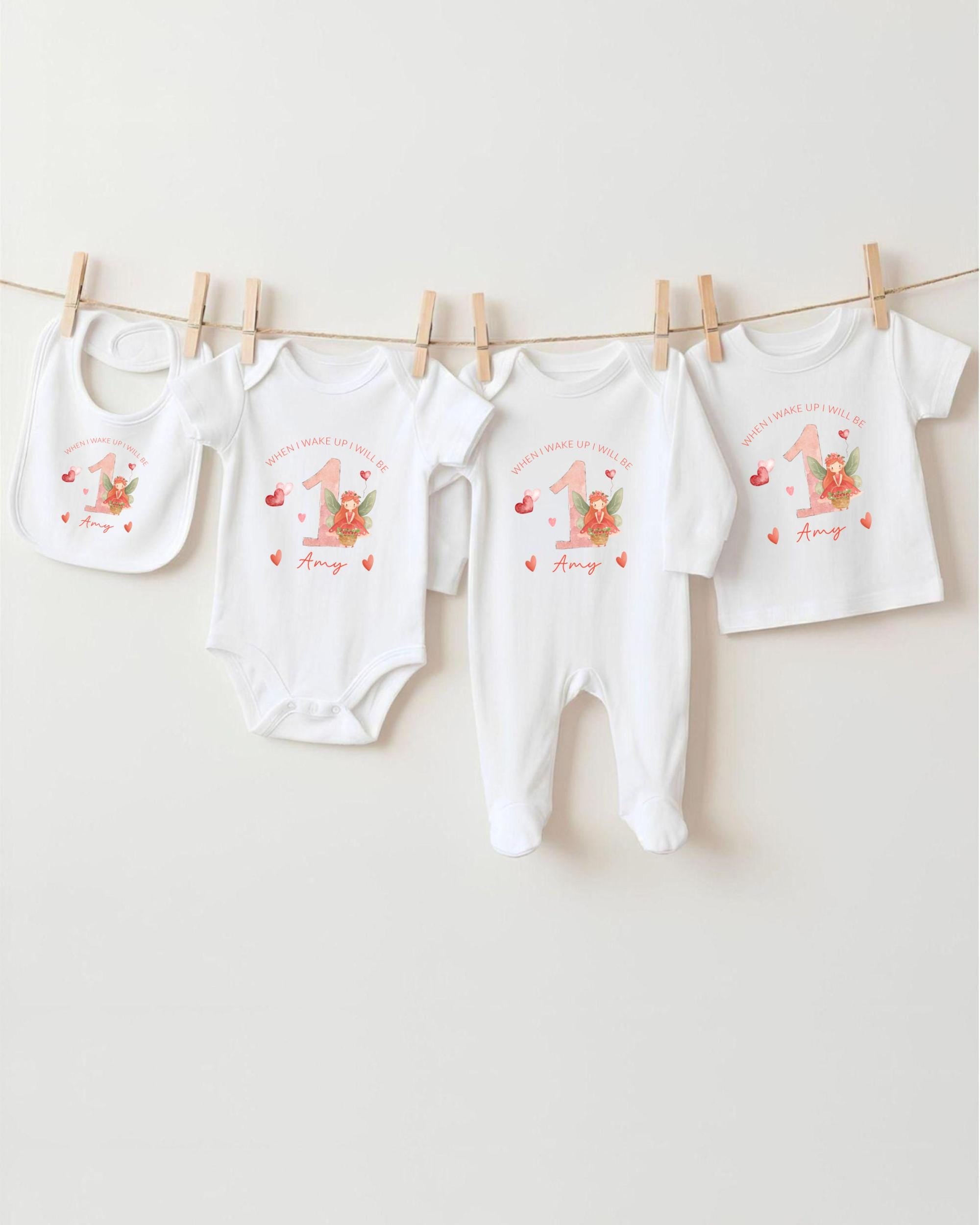 A collection of white baby clothes, including onesies and bibs, hanging on a clothesline.
