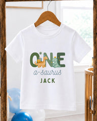A white t-shirt with a graphic design featuring a dinosaur and the text "ONE a-saurus JACK" printed on it.