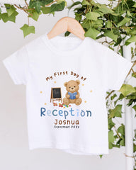 A white t-shirt with a teddy bear and a chalkboard, along with the text "My First Day of Reception Joshua September 2023".
