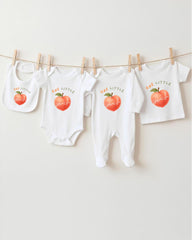a collection of baby clothes, including onesies and bibs, hanging on a clothesline.