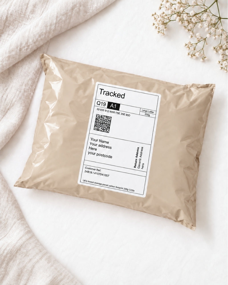 postal mail bag with a tracked shipping label showing generic recipient and sender addresses, styled on a white background with linen and delicate white flowers.