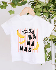 A white t-shirt with a graphic design featuring the text "Totally BANANA" and three bananas.