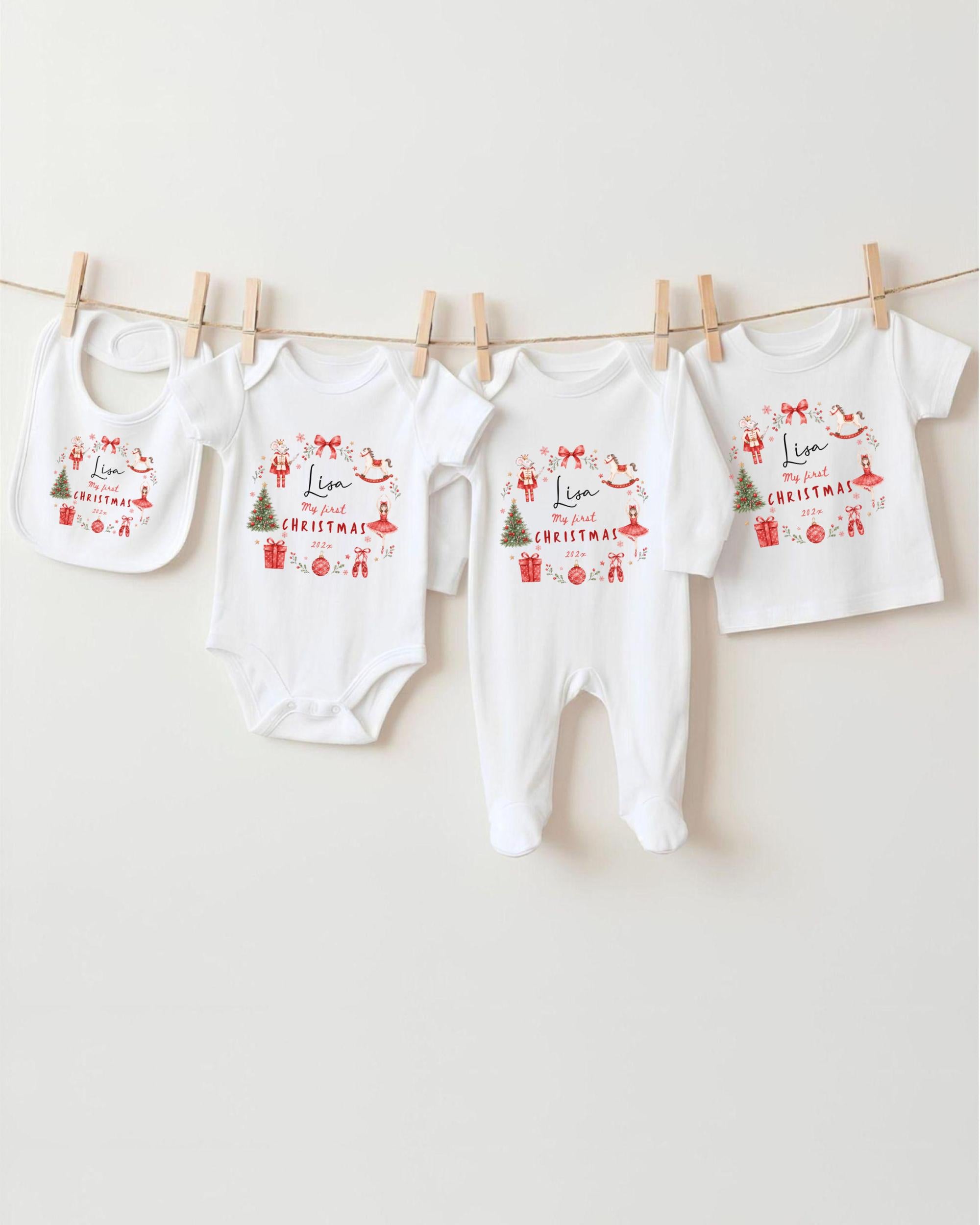 A row of four white baby clothes with Christmas-themed designs hanging on a clothesline.