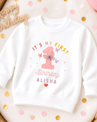 A white sweatshirt with a personalized birthday message printed on it, surrounded by confetti.