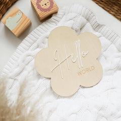 a white blanket with a wooden hello world sign on it