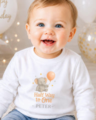 A smiling baby boy wearing a white shirt with an elephant and balloon graphic, and the text "Half Way to One - Peter" printed on it.