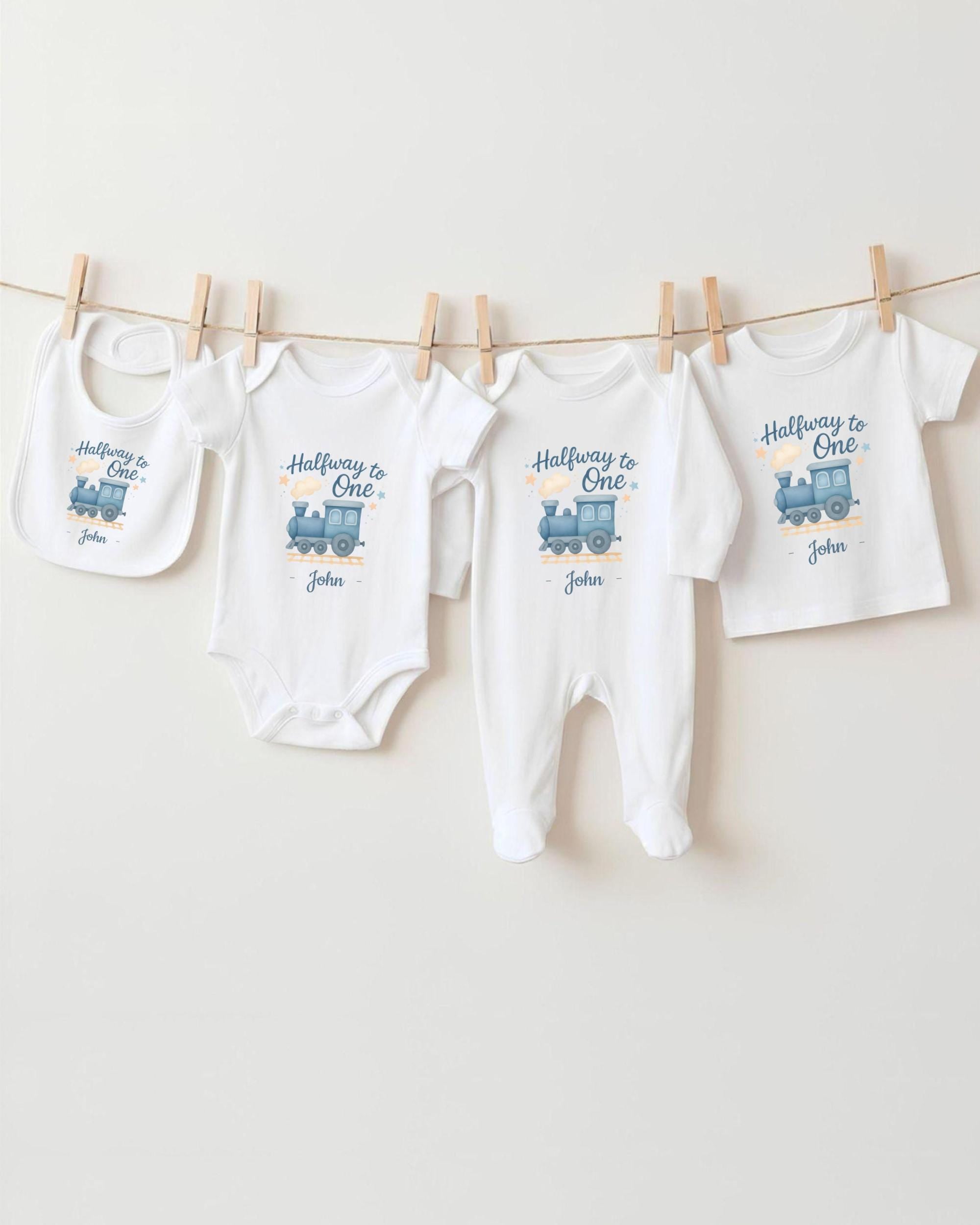 A collection of baby clothes, including onesies and bibs, hanging on a clothesline.