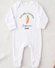 A white onesie with a printed design of a carrot and the text "Locally Grown Jessica 2026" printed on it.