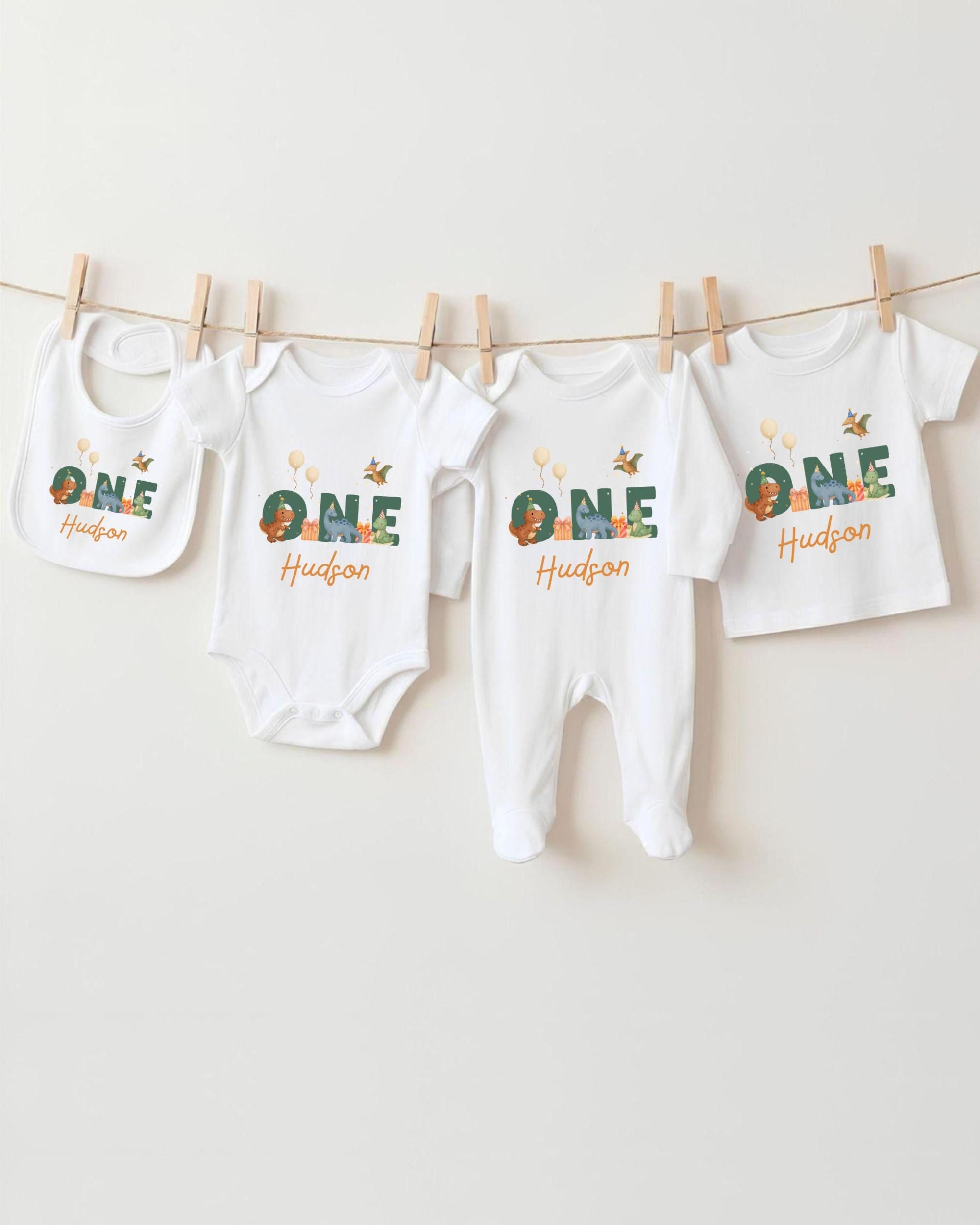A collection of white baby clothes, including onesies and pajamas, hanging on a clothesline.